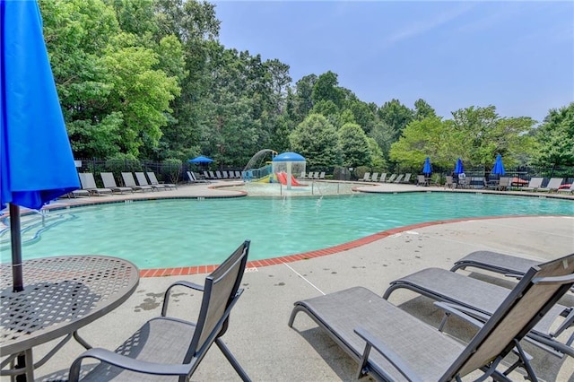 pool with a patio area and fence