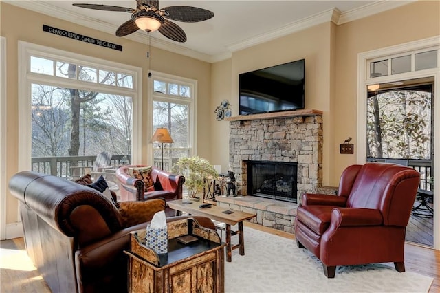 living room featuring crown molding, hardwood / wood-style floors, a fireplace, and ceiling fan