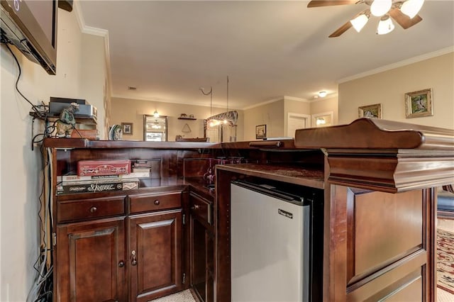 kitchen with crown molding, ceiling fan, dark brown cabinets, and stainless steel refrigerator