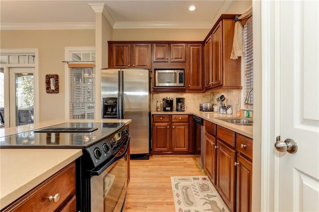 kitchen with decorative backsplash, light hardwood / wood-style flooring, ornamental molding, sink, and stainless steel appliances