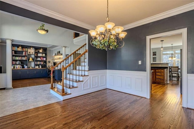 unfurnished dining area with stairs, wood finished floors, and a notable chandelier