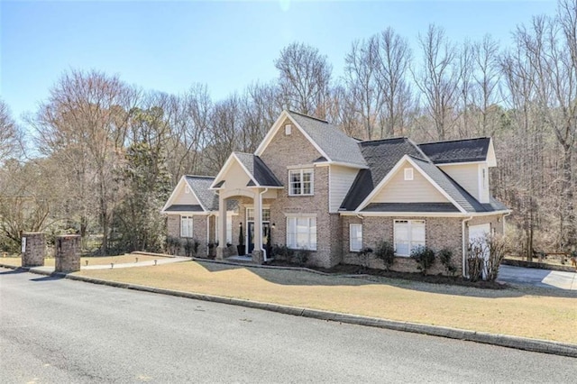 traditional-style home featuring a front lawn and brick siding