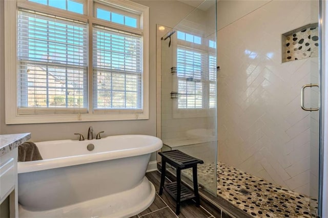 full bath with a freestanding tub, wood finished floors, and a stall shower