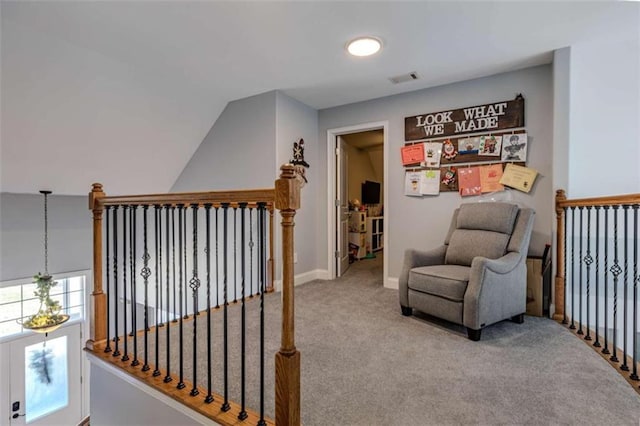 living area featuring carpet floors, lofted ceiling, an upstairs landing, and baseboards