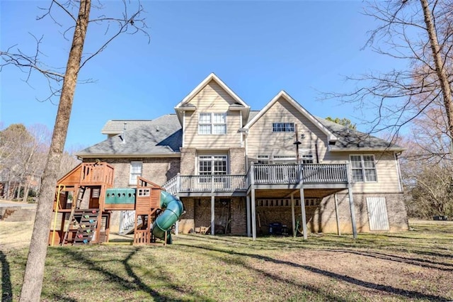 rear view of property featuring a deck, a yard, and a playground