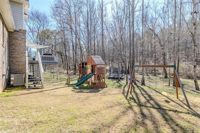 view of play area with stairway, a trampoline, a lawn, and cooling unit