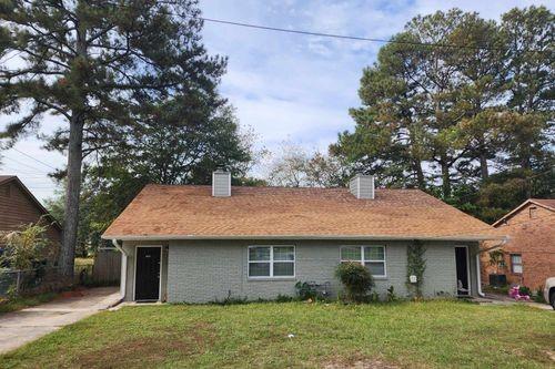 rear view of property featuring a lawn