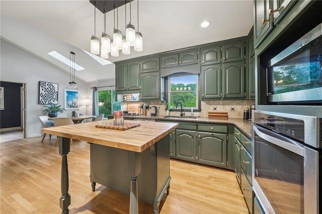 177 Coopers Pond Dr, Lawrenceville, GA 30044 - kitchen featuring stainless steel appliances, green cabinetry, a sink, wood counters, and tasteful backsplash