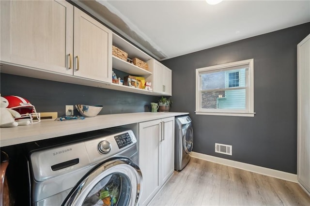 177 Coopers Pond Dr, Lawrenceville, GA 30044 - laundry room with cabinet space, washing machine and clothes dryer, light wood finished floors, and baseboards