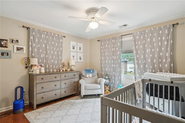 177 Coopers Pond Dr, Lawrenceville, GA 30044 - bedroom featuring wood finished floors, a nursery area, crown molding, baseboards, and ceiling fan