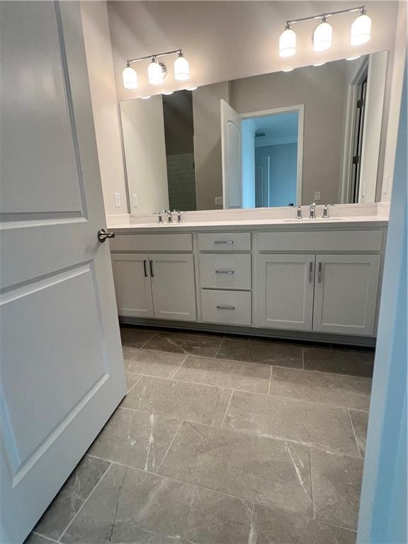 full bathroom with double vanity and a sink