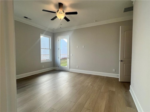 unfurnished room featuring dark wood-type flooring, crown molding, baseboards, and ceiling fan