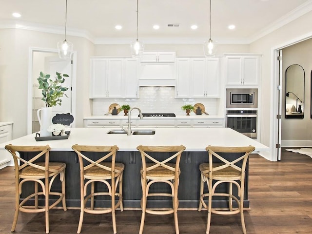 kitchen with a sink, white cabinetry, appliances with stainless steel finishes, and backsplash