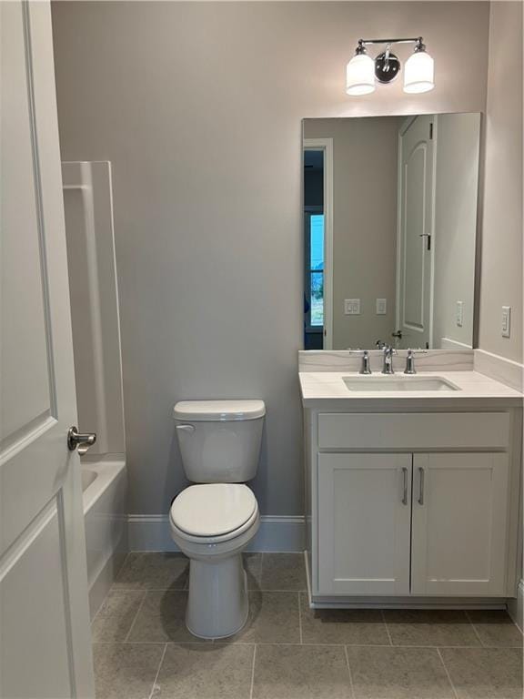 bathroom with vanity, baseboards, tile patterned flooring, and toilet