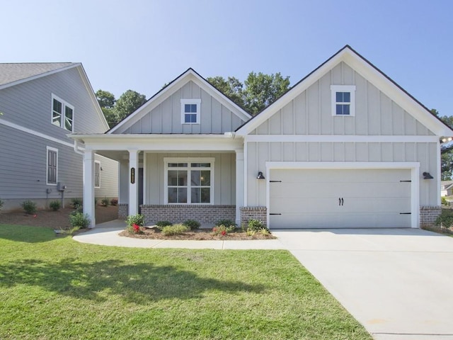 craftsman-style home with a garage, board and batten siding, a front yard, and brick siding