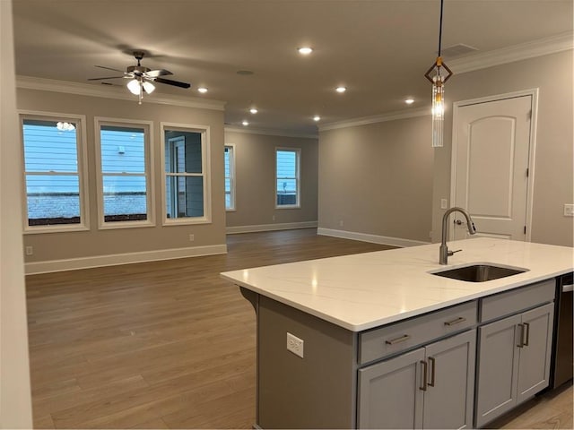 kitchen with crown molding, open floor plan, gray cabinetry, and a sink