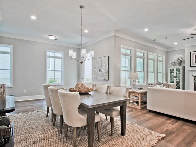 dining space with a chandelier, recessed lighting, baseboards, wood finished floors, and ornamental molding