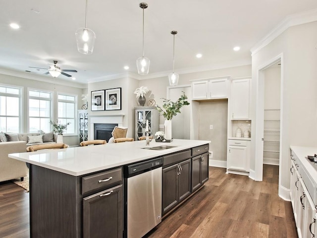 kitchen featuring ornamental molding, open floor plan, white cabinets, a sink, and dishwasher