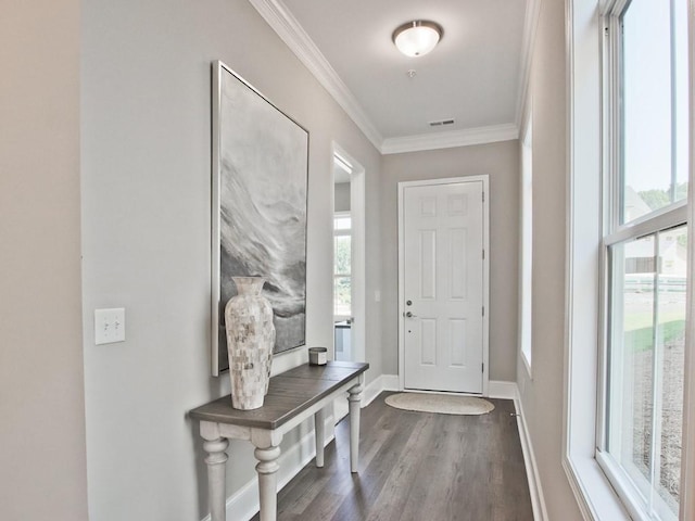 entryway with dark wood-type flooring, ornamental molding, baseboards, and visible vents