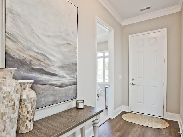 entryway with visible vents, ornamental molding, baseboards, and wood finished floors