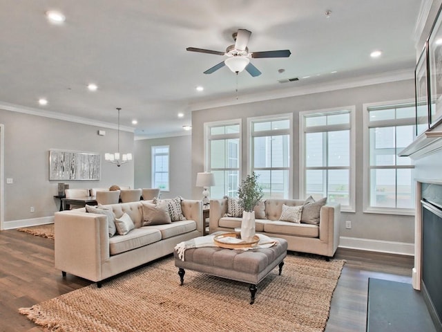living room with visible vents, crown molding, baseboards, ceiling fan with notable chandelier, and dark wood-type flooring