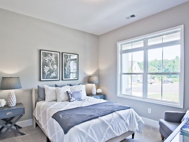 carpeted bedroom featuring baseboards and visible vents