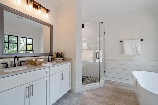 bathroom featuring vanity, separate shower and tub, and wood-type flooring