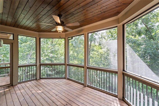 unfurnished sunroom with ceiling fan, a healthy amount of sunlight, and wooden ceiling