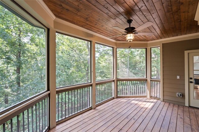 unfurnished sunroom with a healthy amount of sunlight, ceiling fan, and wooden ceiling