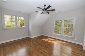 bonus room featuring plenty of natural light, dark hardwood / wood-style flooring, and lofted ceiling