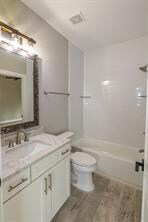 full bathroom featuring vanity, toilet, and  shower combination