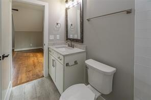 bathroom with vanity, toilet, and wood-type flooring