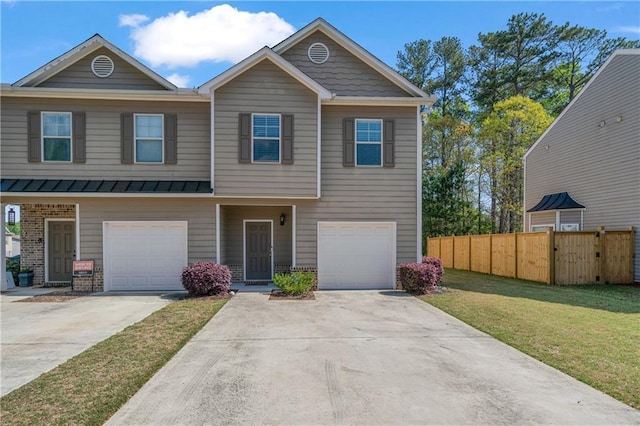view of front of property featuring driveway, an attached garage, fence, a front lawn, and a standing seam roof