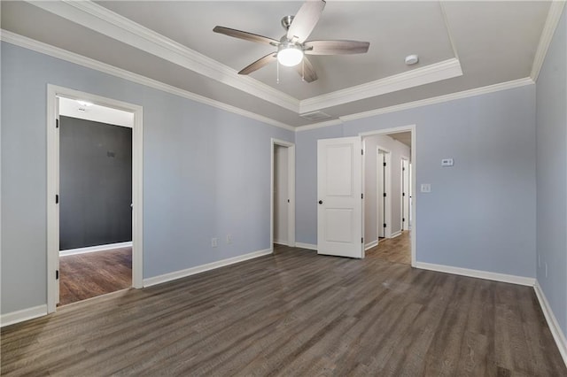 spare room featuring baseboards, a raised ceiling, ornamental molding, ceiling fan, and wood finished floors