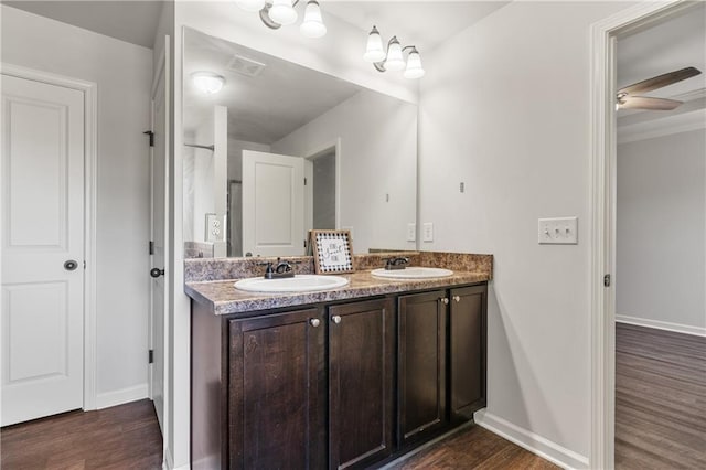 full bath featuring wood finished floors, double vanity, a sink, and visible vents