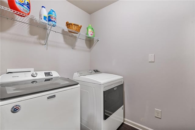 laundry area featuring laundry area, baseboards, and washer and clothes dryer