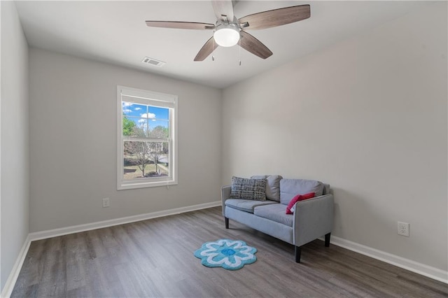 sitting room with ceiling fan, baseboards, and wood finished floors