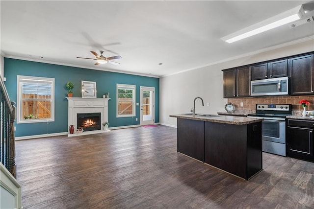 kitchen with a sink, decorative backsplash, dark wood-style flooring, and stainless steel appliances