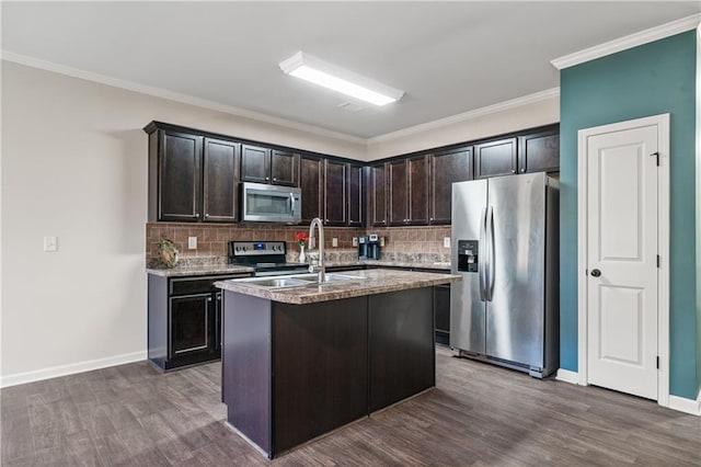kitchen featuring tasteful backsplash, a sink, dark brown cabinetry, dark wood-style floors, and stainless steel appliances