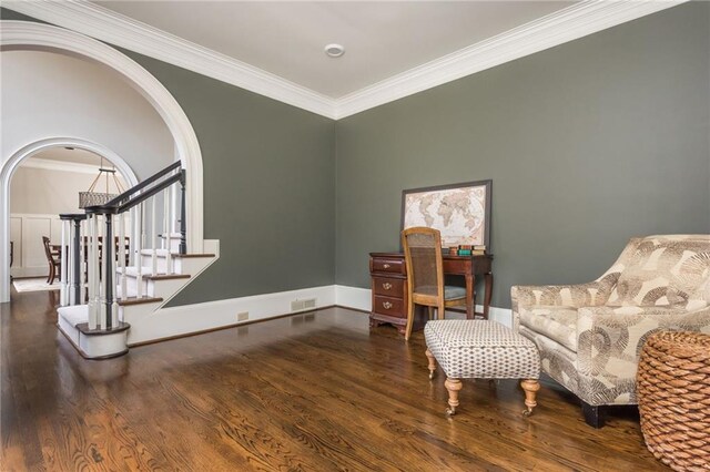 entrance foyer with stairs, crown molding, baseboards, arched walkways, and dark wood-type flooring