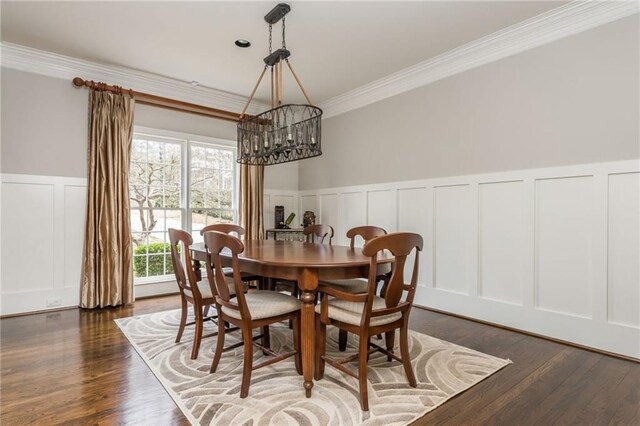 dining area featuring arched walkways, a wainscoted wall, wood finished floors, and crown molding
