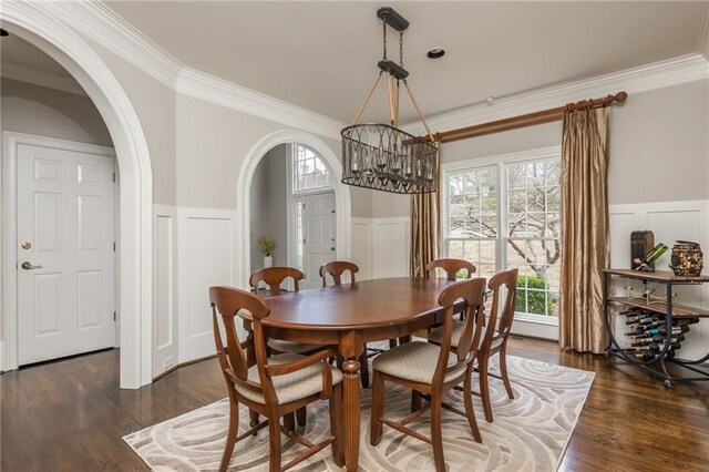 entrance foyer with arched walkways, baseboards, stairway, and wood finished floors