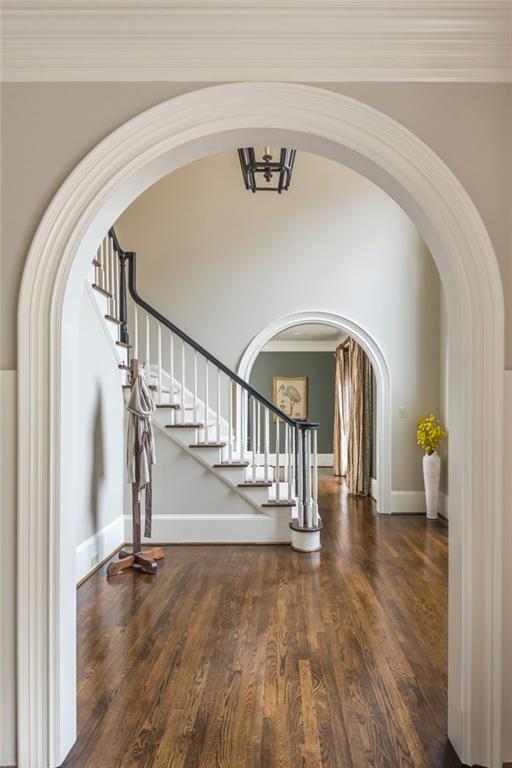 dining room featuring plenty of natural light, crown molding, and arched walkways
