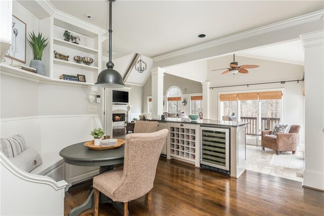 dining space with arched walkways, dark wood-style flooring, ornamental molding, and baseboards