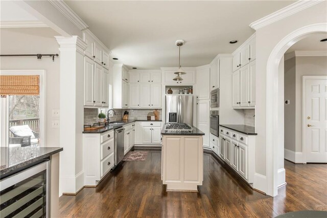 kitchen with dark wood finished floors, a sink, backsplash, and appliances with stainless steel finishes
