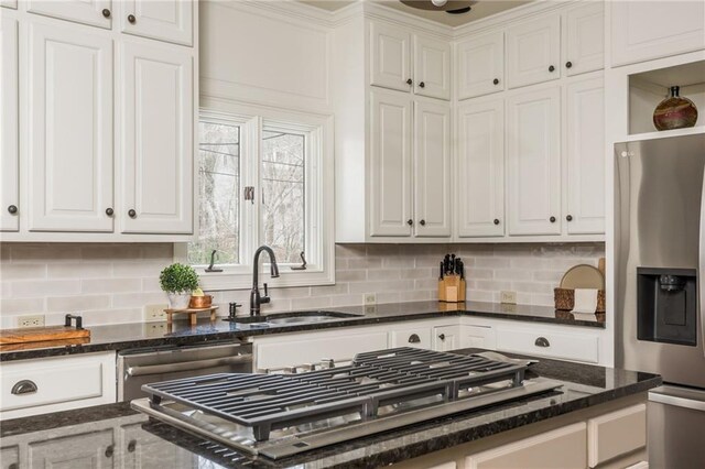 kitchen featuring a sink, white cabinets, dishwasher, and tasteful backsplash