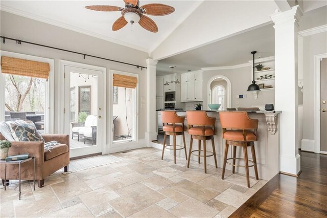 kitchen featuring ornamental molding, a kitchen bar, and dark countertops