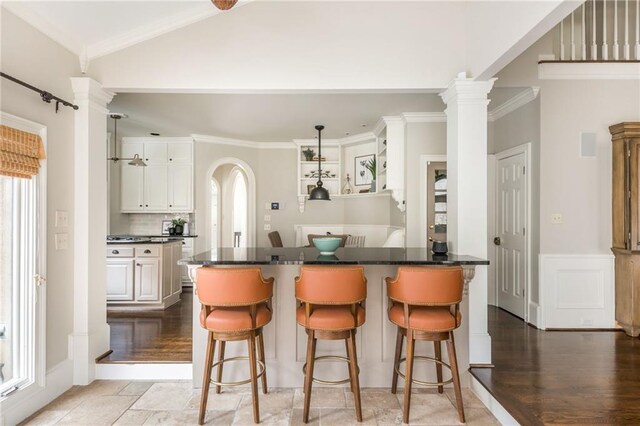 living room with vaulted ceiling with beams, crown molding, stairway, and stone tile flooring