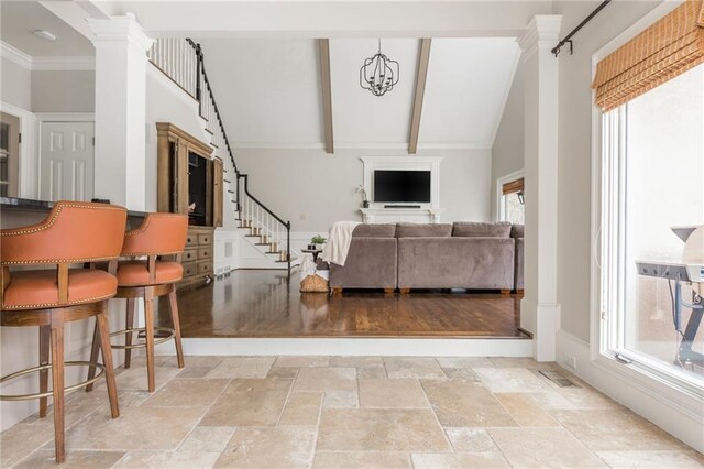 living area featuring dark wood-type flooring, stairs, vaulted ceiling with beams, and visible vents