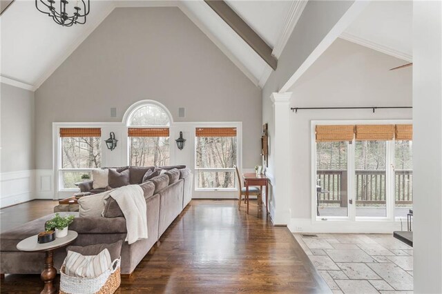 living area with a fireplace with flush hearth, wood finished floors, a healthy amount of sunlight, and stairway